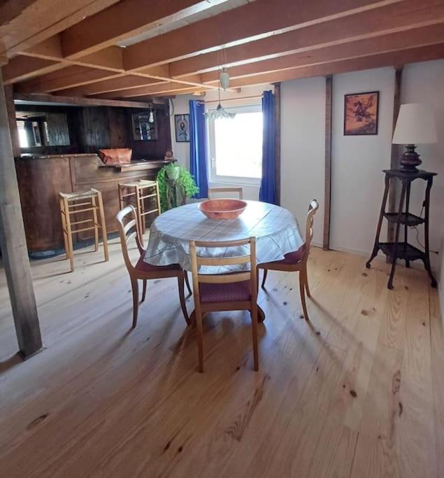 une salle à manger avec une table et des chaises dans une pièce dans l'établissement Maison en campagne style western, à Halluin