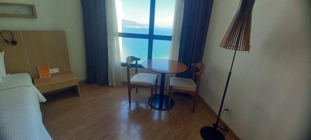 Habitación con mesa, cama y ventana en StarCity Hotel, en Nha Trang