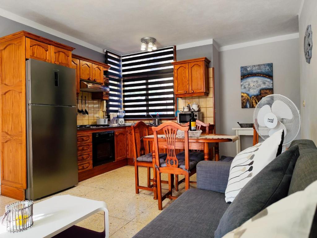 a kitchen and living room with a couch and a refrigerator at Apartamento Any in Puerto Naos