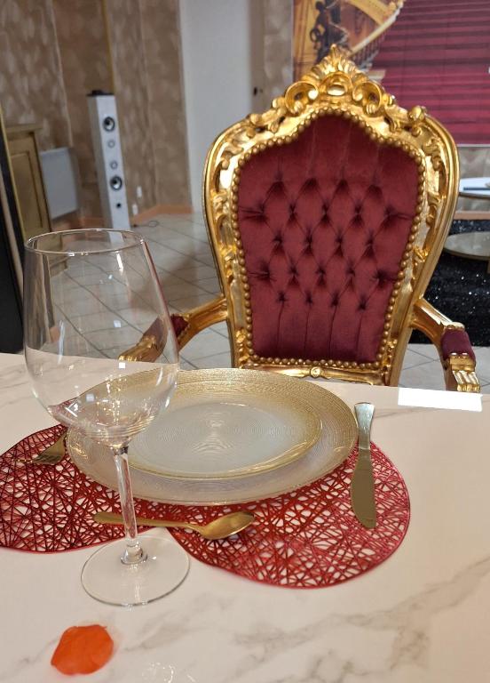 une plaque et un verre sur une table avec une chaise dans l'établissement Romantic room, à Joinville