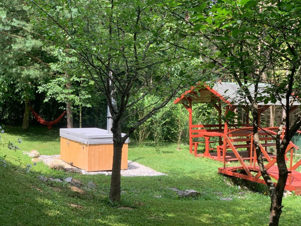 a playground in a yard with a red play structure at Mazsola in Bélapátfalva