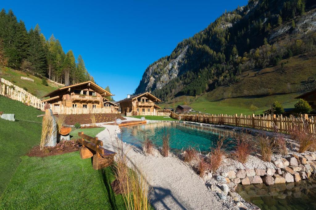 a resort with a swimming pool in the mountains at Chaletdorf Auszeit in Hüttschlag