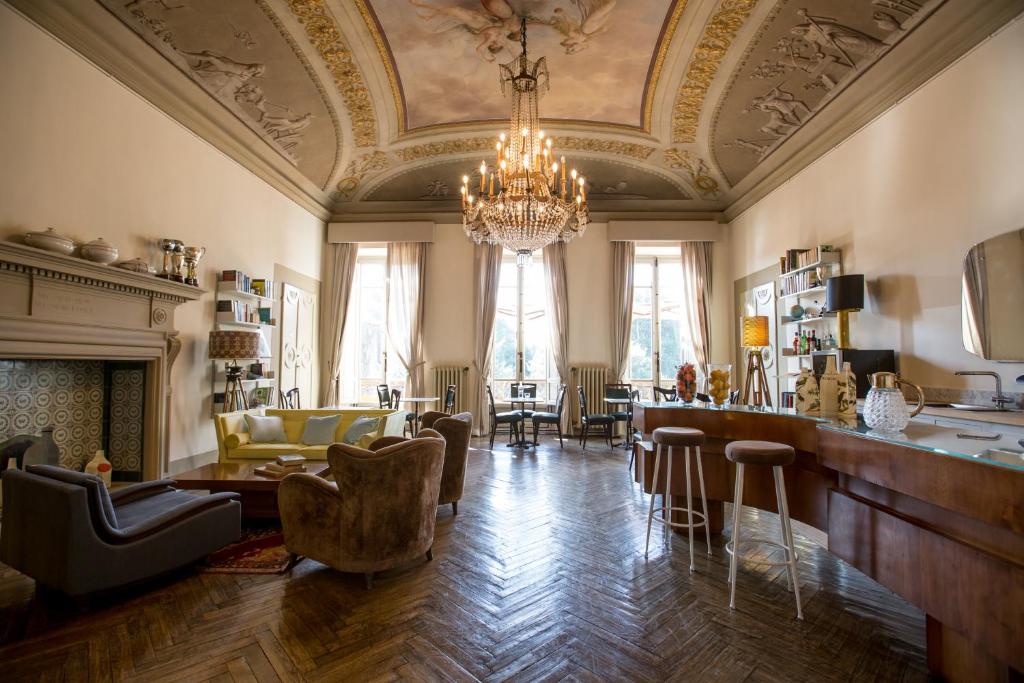 una gran sala de estar con una lámpara de araña y un bar en AdAstra Suites, en Florencia