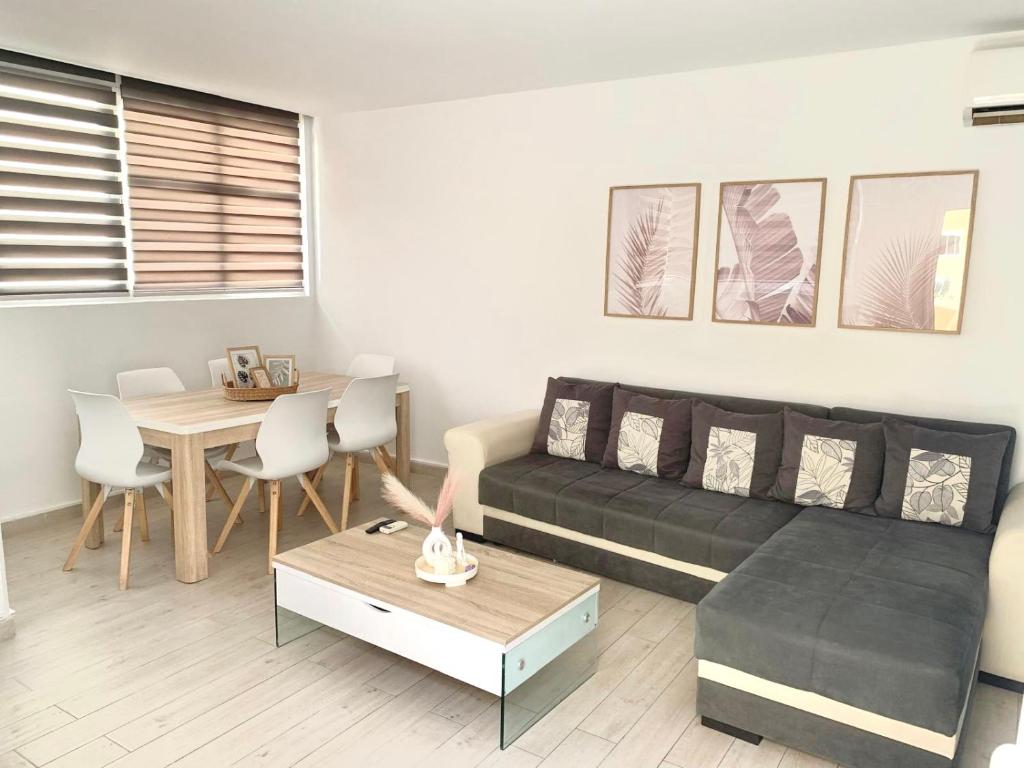 a living room with a black couch and a table at Green sea apartment in Adeje