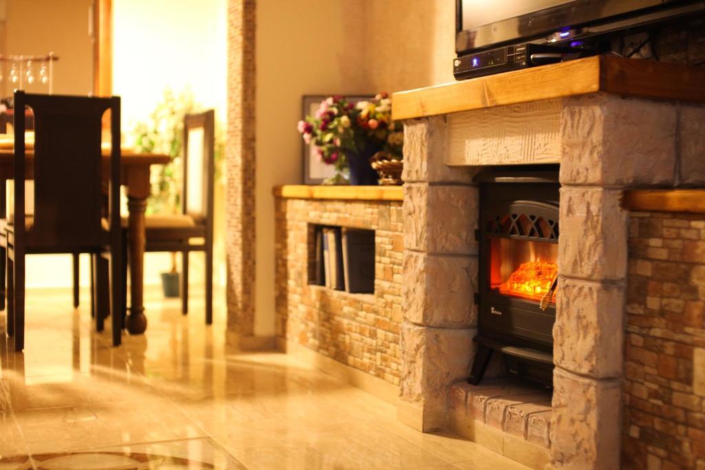 a stone fireplace in a living room with a fire place at Lilia's House in Safed