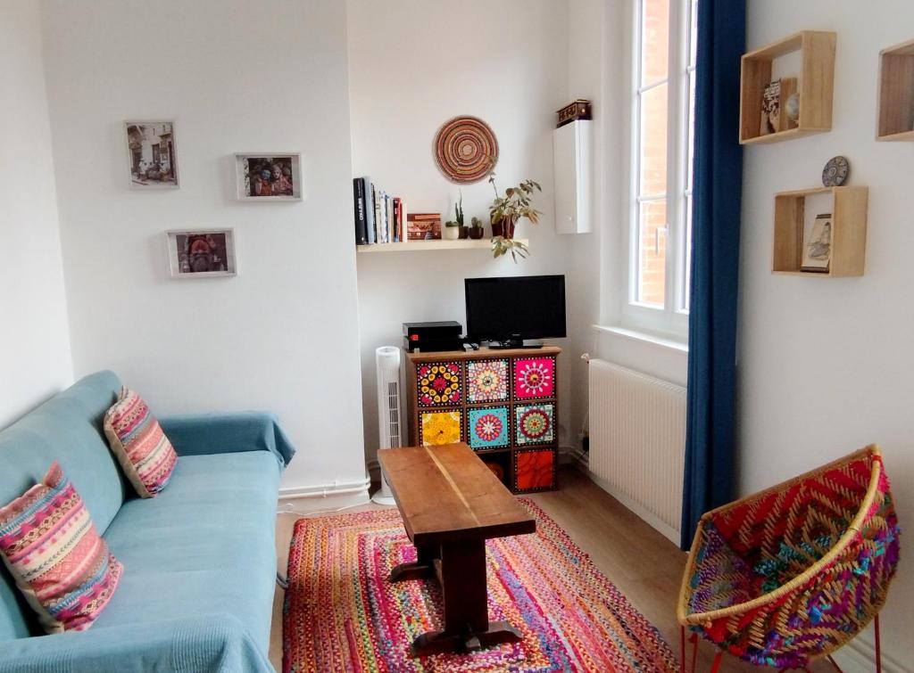 un salon avec un canapé bleu et une table dans l'établissement La casa del mundo, à Toulouse
