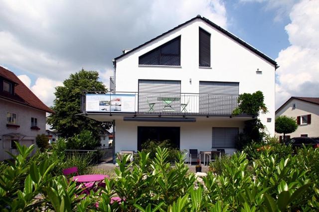 a white house with a balcony on top of it at Casa Fortuna Bodensee in Lindau-Bodolz