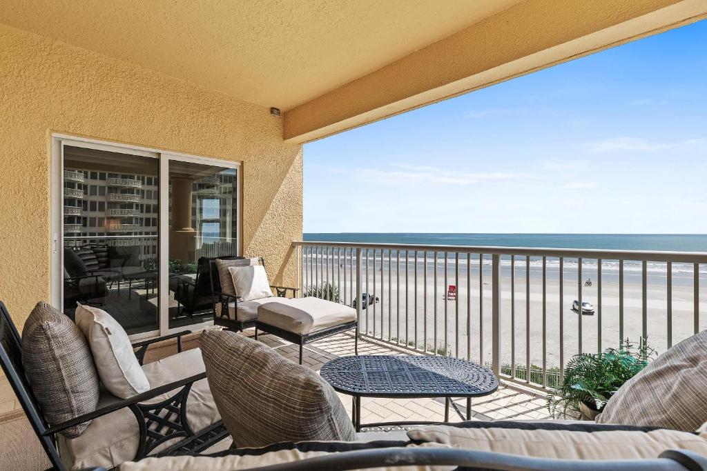 a balcony with chairs and a view of the ocean at Atlantic Villas 301 in New Smyrna Beach