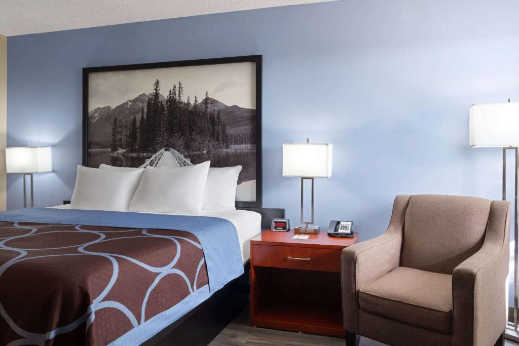 a hotel room with a bed and a chair at Super 8 by Wyndham Sherwood Park/Edmonton Area in Sherwood Park