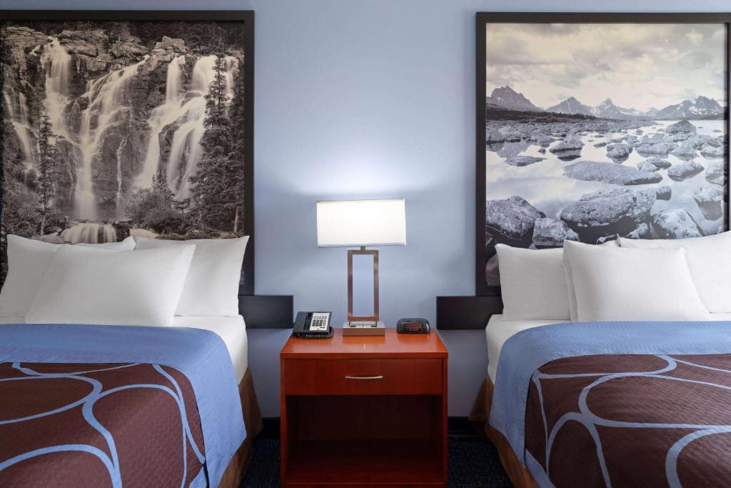 a hotel room with two beds and a table with a lamp at Super 8 by Wyndham Sherwood Park/Edmonton Area in Sherwood Park