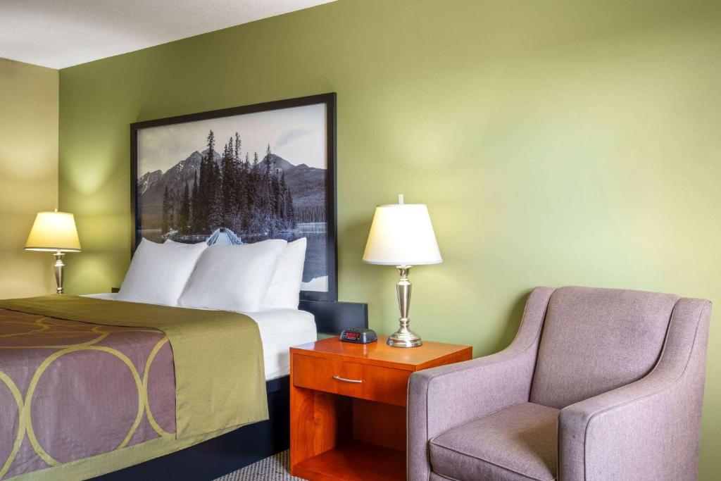 a hotel room with a bed and a chair at Super 8 by Wyndham Sherwood Park/Edmonton Area in Sherwood Park