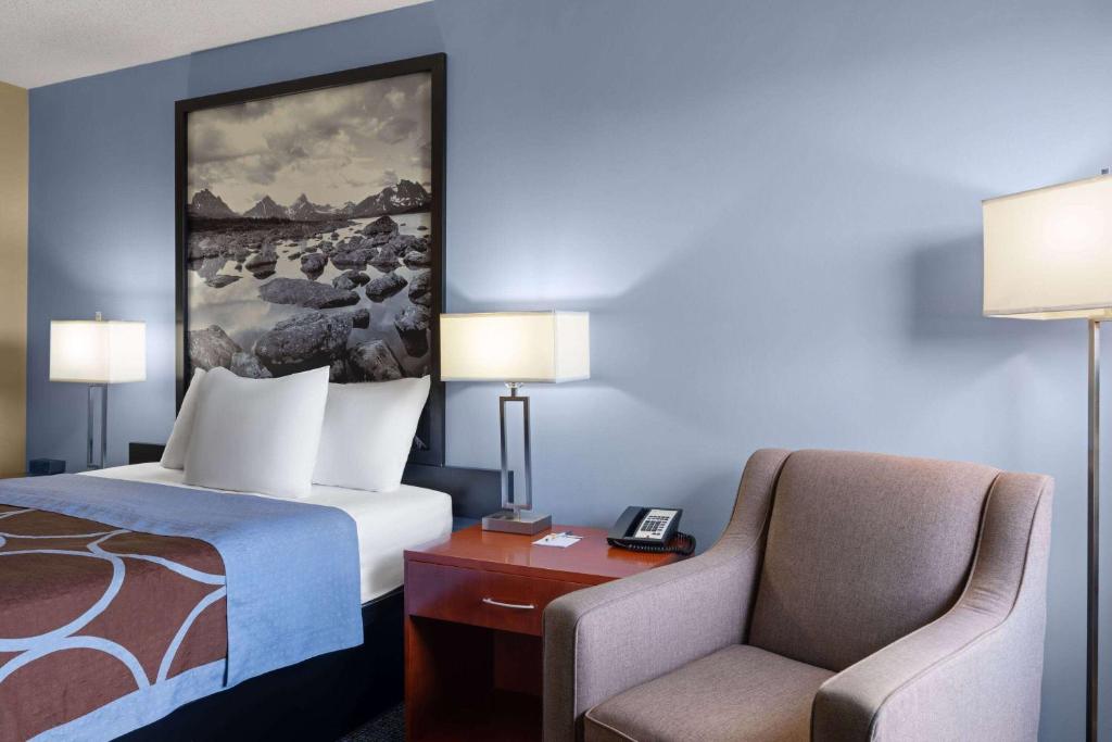 a hotel room with a bed and a chair at Super 8 by Wyndham Sherwood Park/Edmonton Area in Sherwood Park