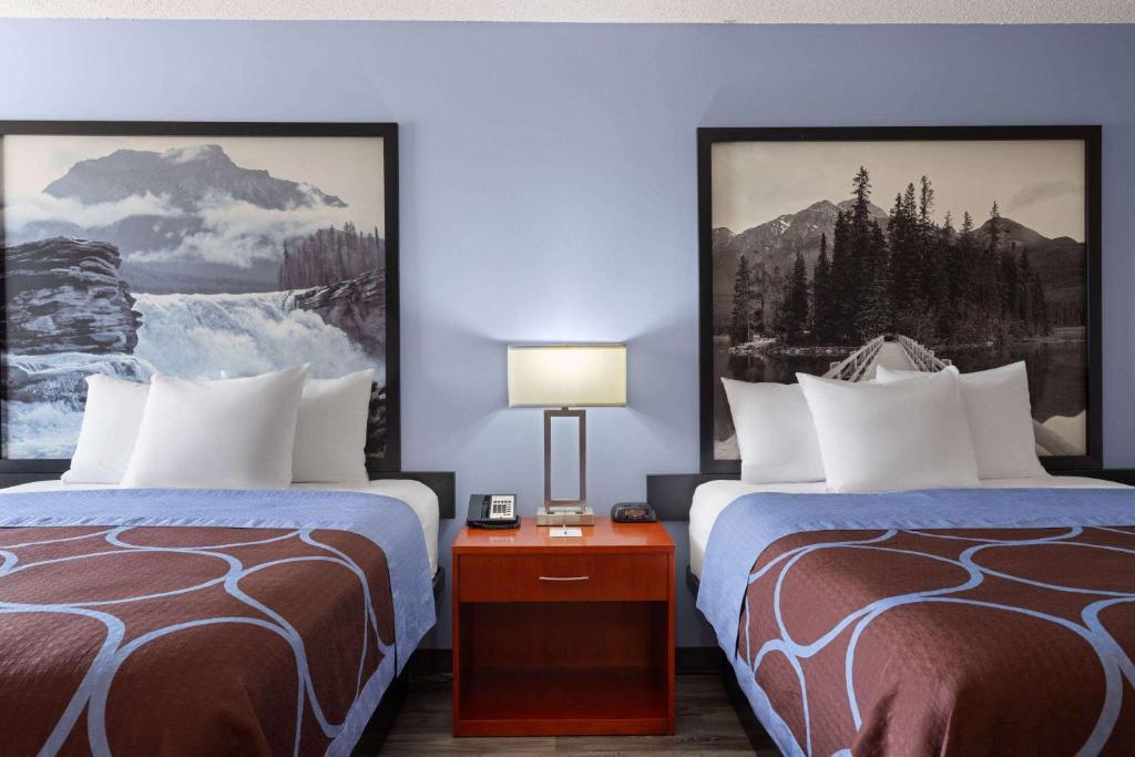 a hotel room with two beds and a lamp at Super 8 by Wyndham Sherwood Park/Edmonton Area in Sherwood Park