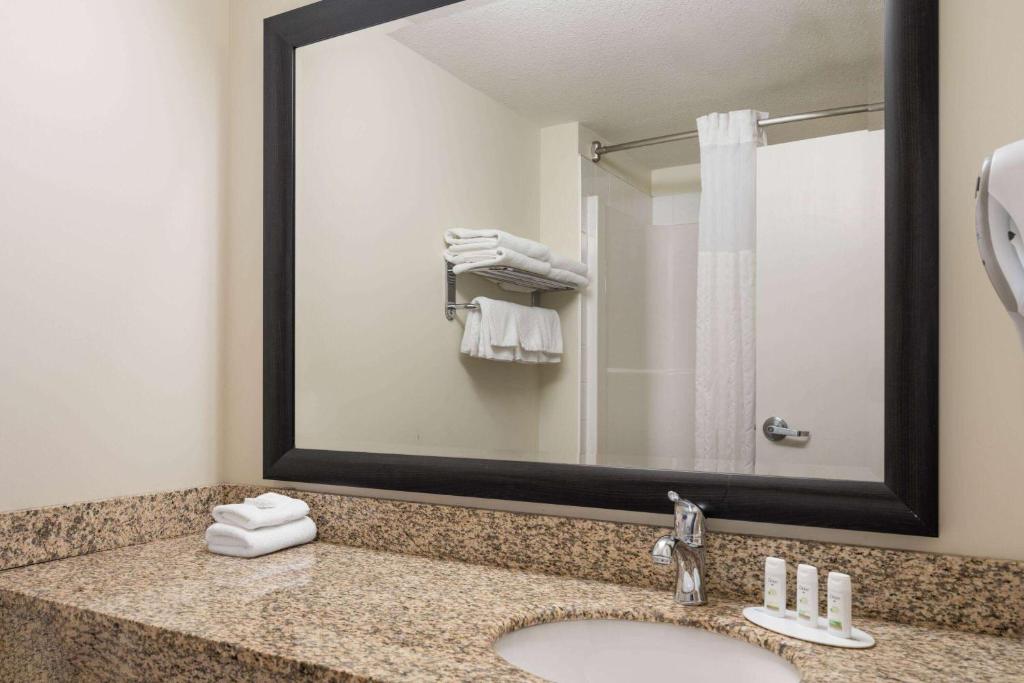 a bathroom with a sink and a mirror at Super 8 by Wyndham Sherwood Park/Edmonton Area in Sherwood Park