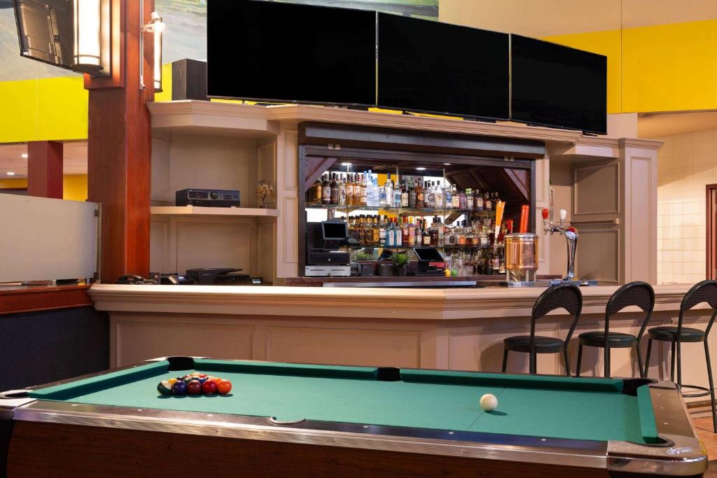 a bar with a pool table in front of a bar at Super 8 by Wyndham Sherwood Park/Edmonton Area in Sherwood Park