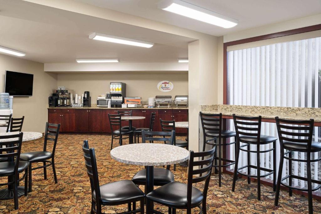 a waiting room with tables and chairs and a counter at Super 8 by Wyndham Sherwood Park/Edmonton Area in Sherwood Park