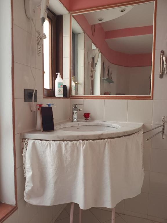 łazienka z białą umywalką i lustrem w obiekcie Apartment ninnananna we Florencji