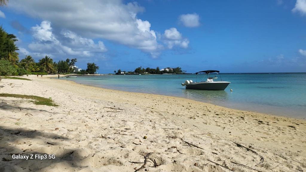 a boat in the water on a beach at Cosey flat Perybere in Grand Baie