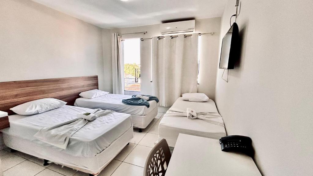 a hospital room with three beds and a window at POUSADA MEDITERRÂNEO in Lagarto