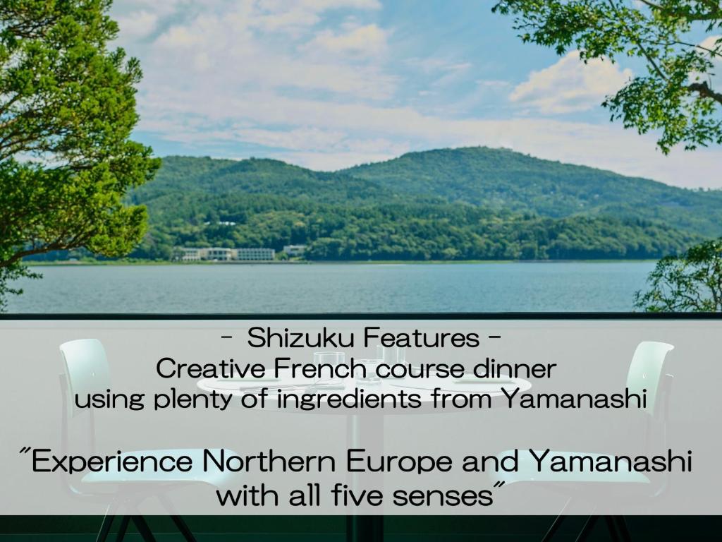 a view of a lake with mountains in the background at Mt Fuji View and Private Sauna Ryokan Shizuku in Yamanakako