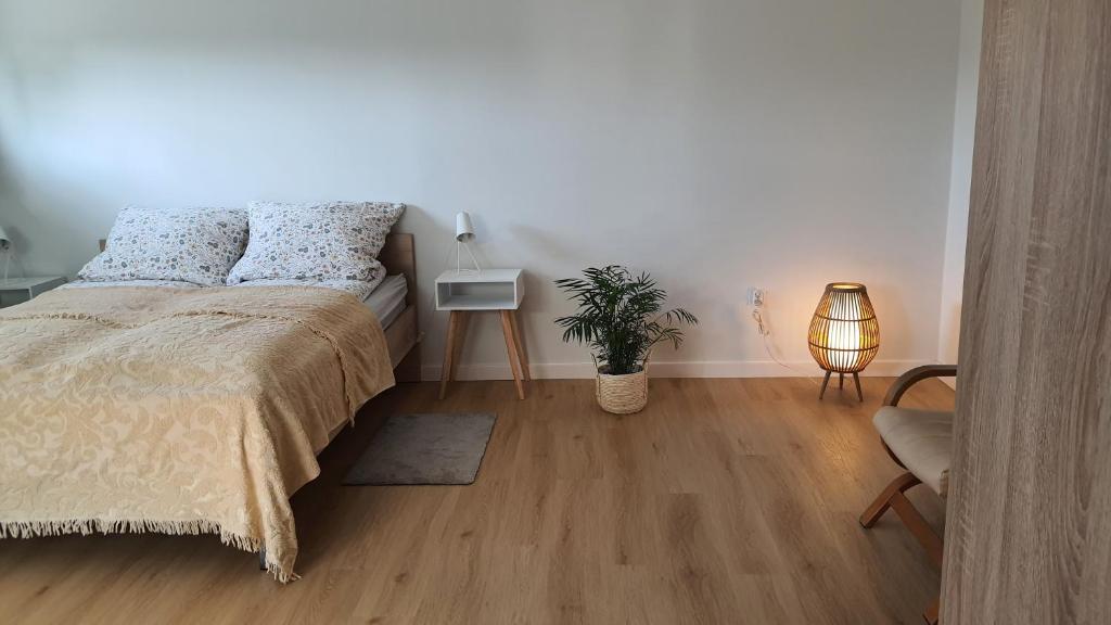 トルンにあるKawalerka 40 m 2 osoby ulica Porzeczkowa Torunのベッドルーム(ベッド1台、テーブル、ランプ付)