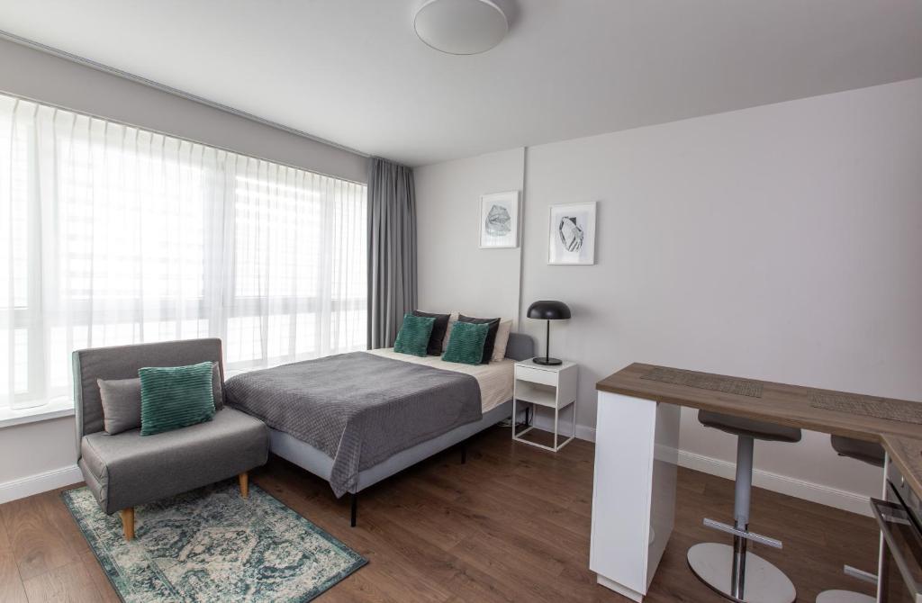 une chambre avec un lit, une chaise et un bureau dans l'établissement Studio Ligita near Egle, à Druskininkai