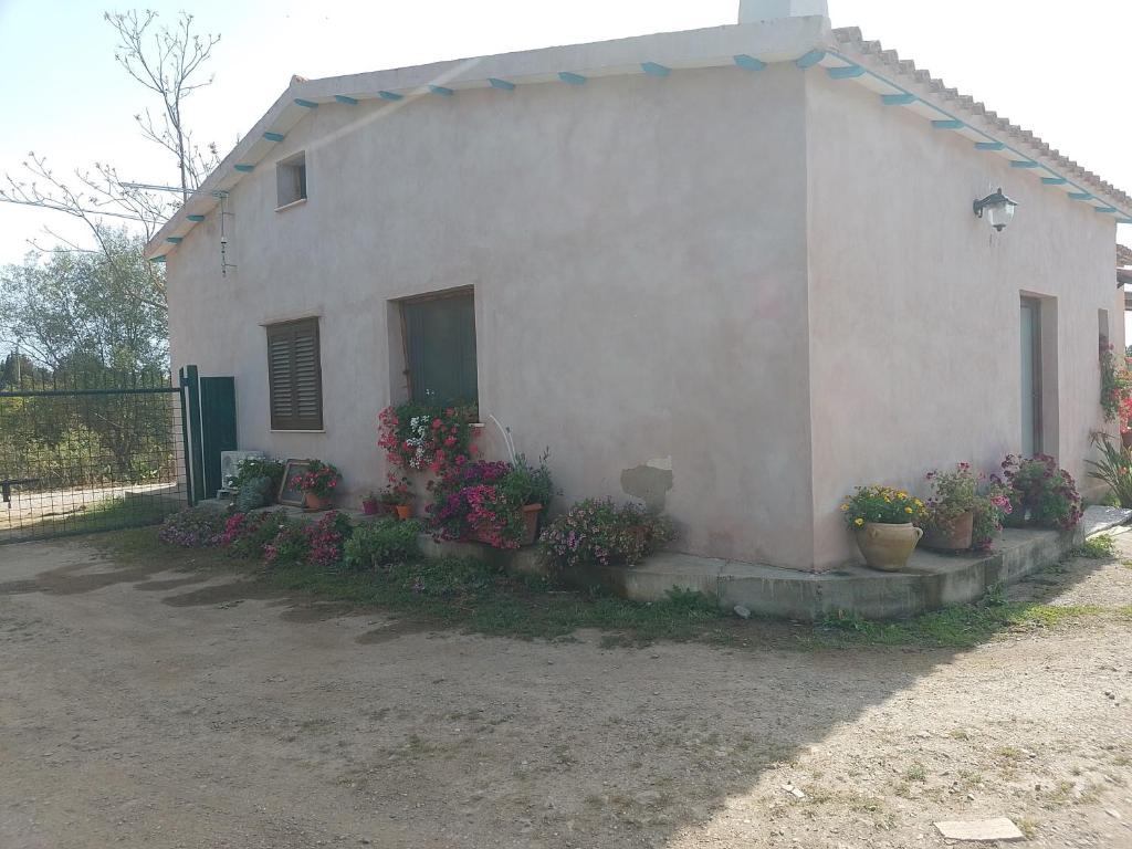 ein weißes Haus mit Blumen davor in der Unterkunft Casa in campagna in Capoterra