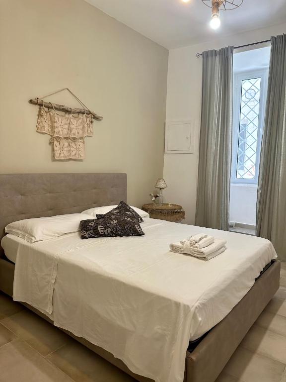 a bedroom with a bed with white sheets and a window at Ercolano Civitas in Ercolano