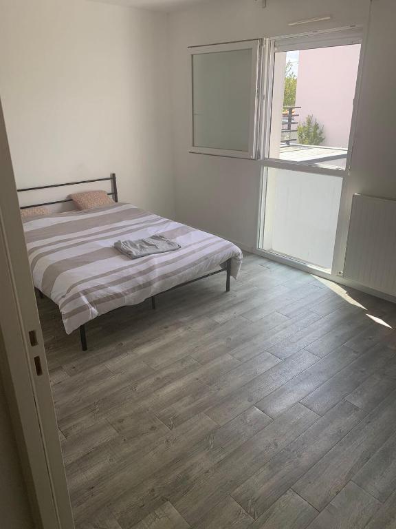 une chambre avec un lit et une grande fenêtre dans l'établissement La chantrerie, à Nantes