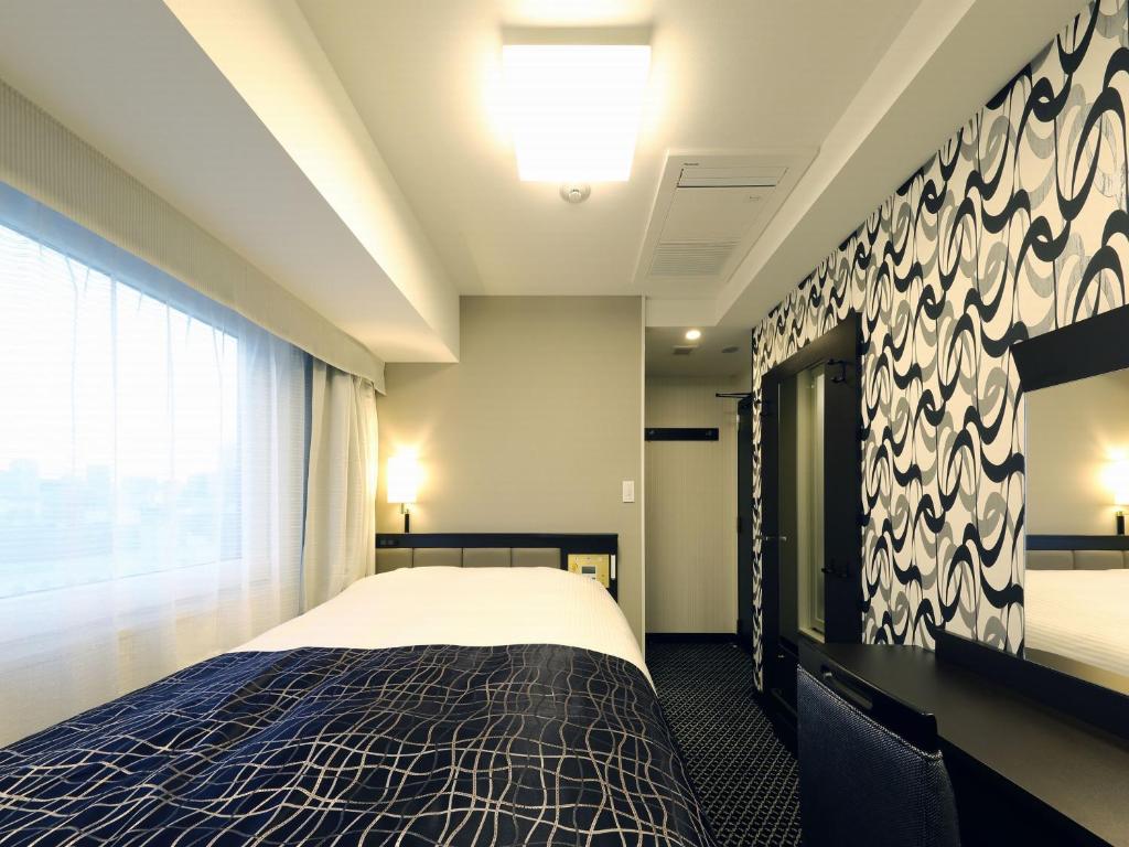 Postel nebo postele na pokoji v ubytování APA Hotel Ueno Inaricho Ekikita