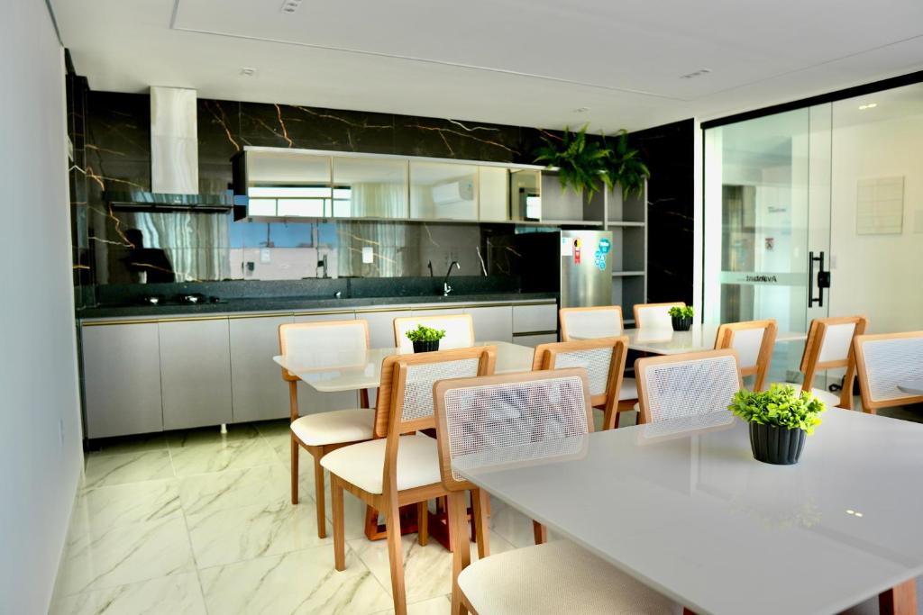 a dining room with a white table and chairs at Feel Home - Flat Sofisticado Próximo a Praia in Cabedelo
