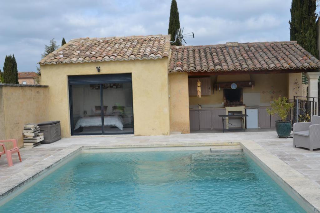 une maison avec une piscine devant une maison dans l'établissement Chez Véronique et Jean Daniel, à Maubec