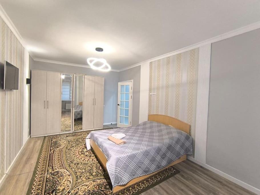 a bedroom with a bed and a large rug at Уютная квартира в парковой зоне in Chong-Aryk