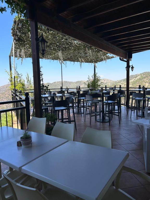 a row of tables and chairs on a patio at Two Flowers Hotel in Pedoulas