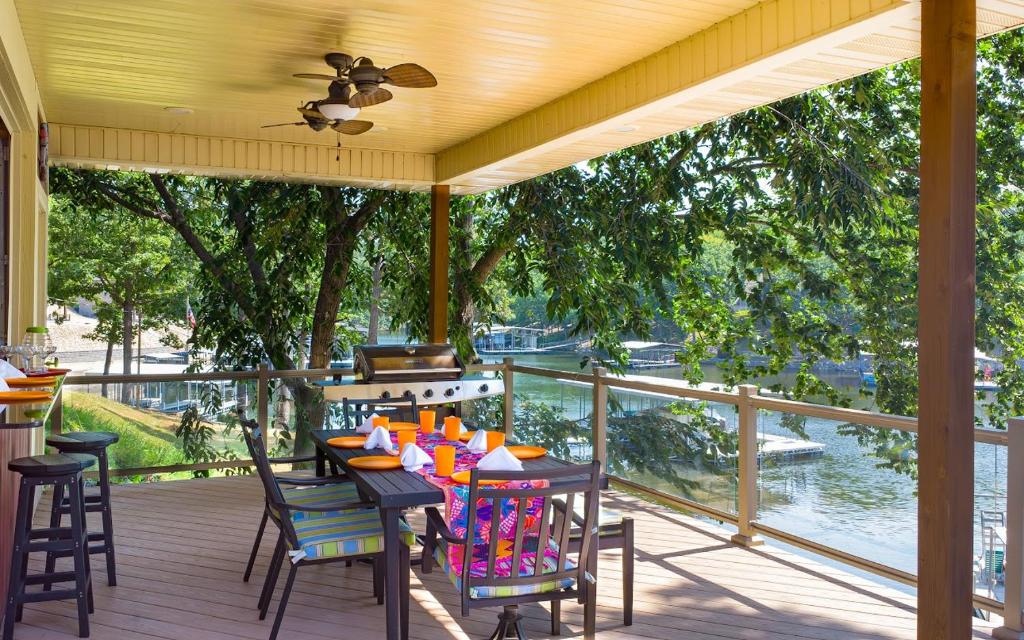 a porch with a table and chairs and a grill at Barba Le Lane in Lake Ozark