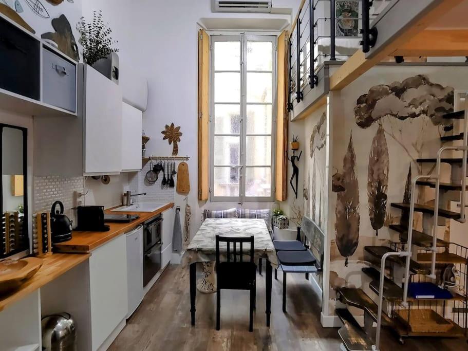 une cuisine avec une table et des chaises et une fenêtre dans l'établissement Studio Mimosa Duplex in old town, 200m to beach, à Nice