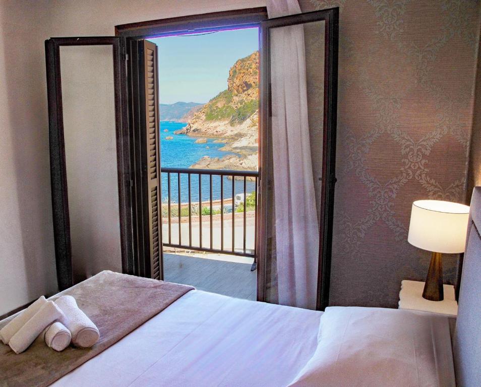 a bedroom with a bed with a view of the ocean at Hôtel Le Golfe Ecolabel EU in Porto Ota