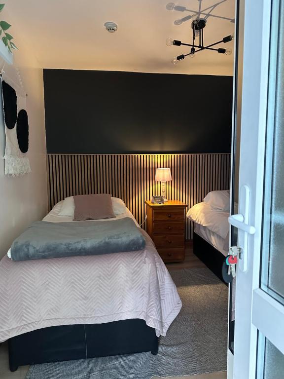 a bedroom with two beds and a lamp on a table at Malahide Guest Rooms in Malahide