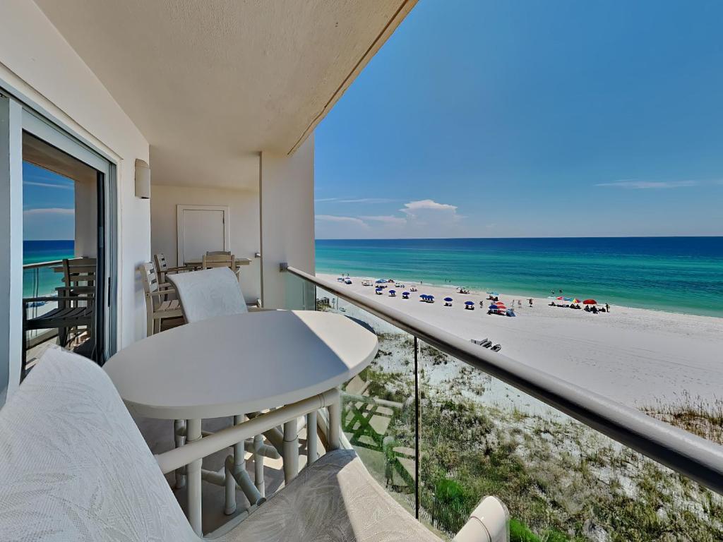 einen Balkon mit einem Tisch und Strandblick in der Unterkunft Regency Towers #605 West in Pensacola Beach