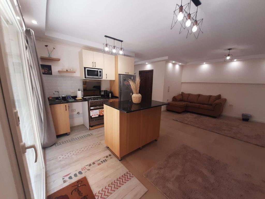 a kitchen and living room with a couch and a table at New Cairo Zoé in Cairo