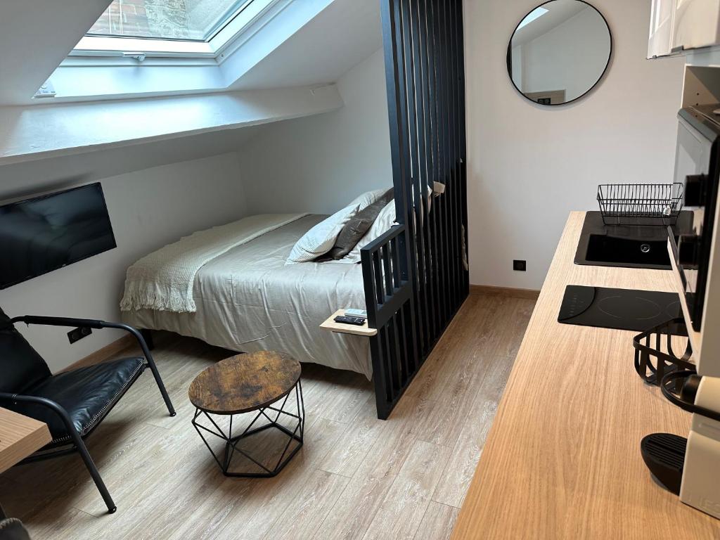 une chambre avec un lit, un miroir et une chaise dans l'établissement Le Studio Bellifontain, à Fontainebleau