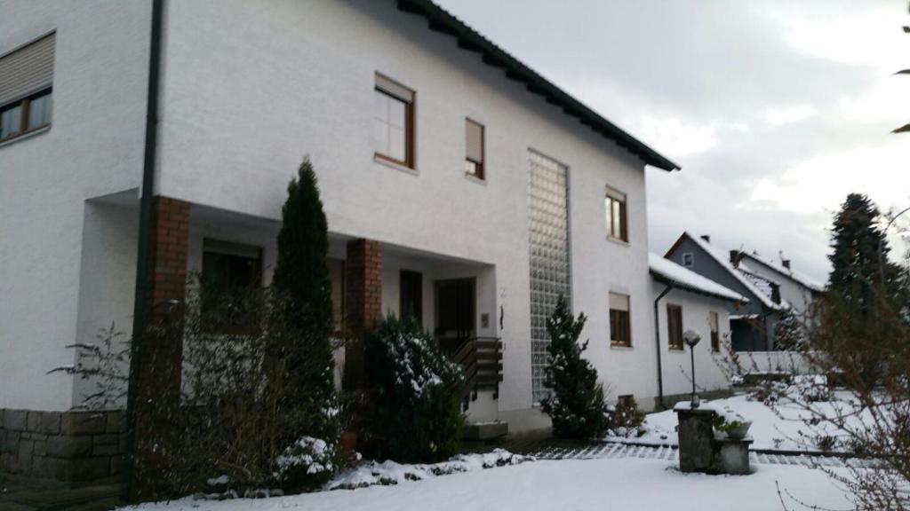 Biały dom z śniegiem przed nim w obiekcie Haus Eva w mieście Eslarn