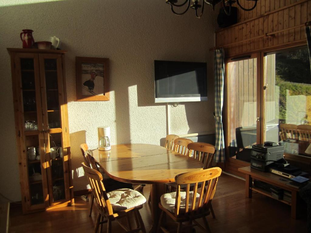 - une salle à manger avec une table et des chaises en bois dans l'établissement Les Gets Le Grand Paradis, aux Gets