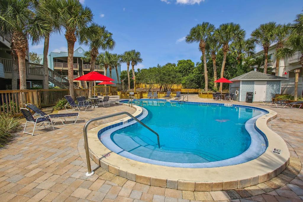 a swimming pool with chairs and umbrellas in a resort at Beachfront Gem Core of St Augustine in Saint Augustine