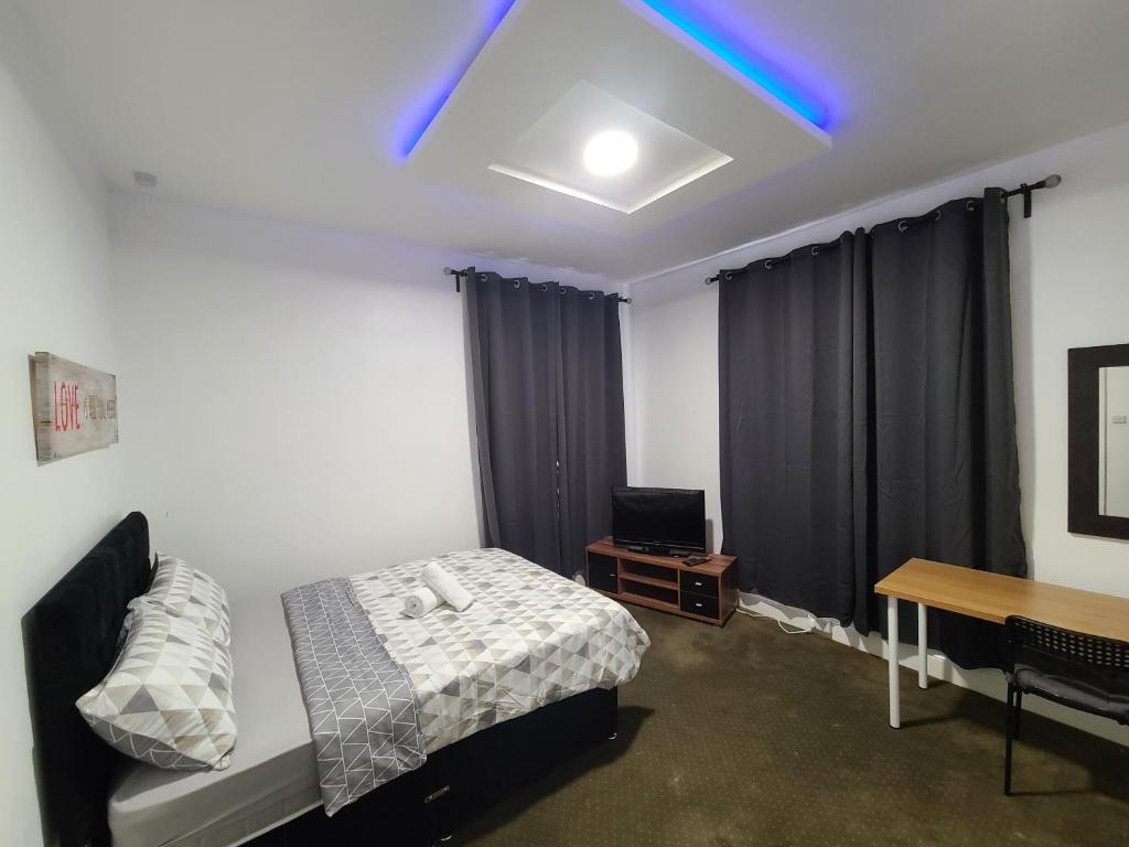 sypialnia z łóżkiem i biurkiem z laptopem w obiekcie Elegant Spacious Home w mieście Middlesbrough