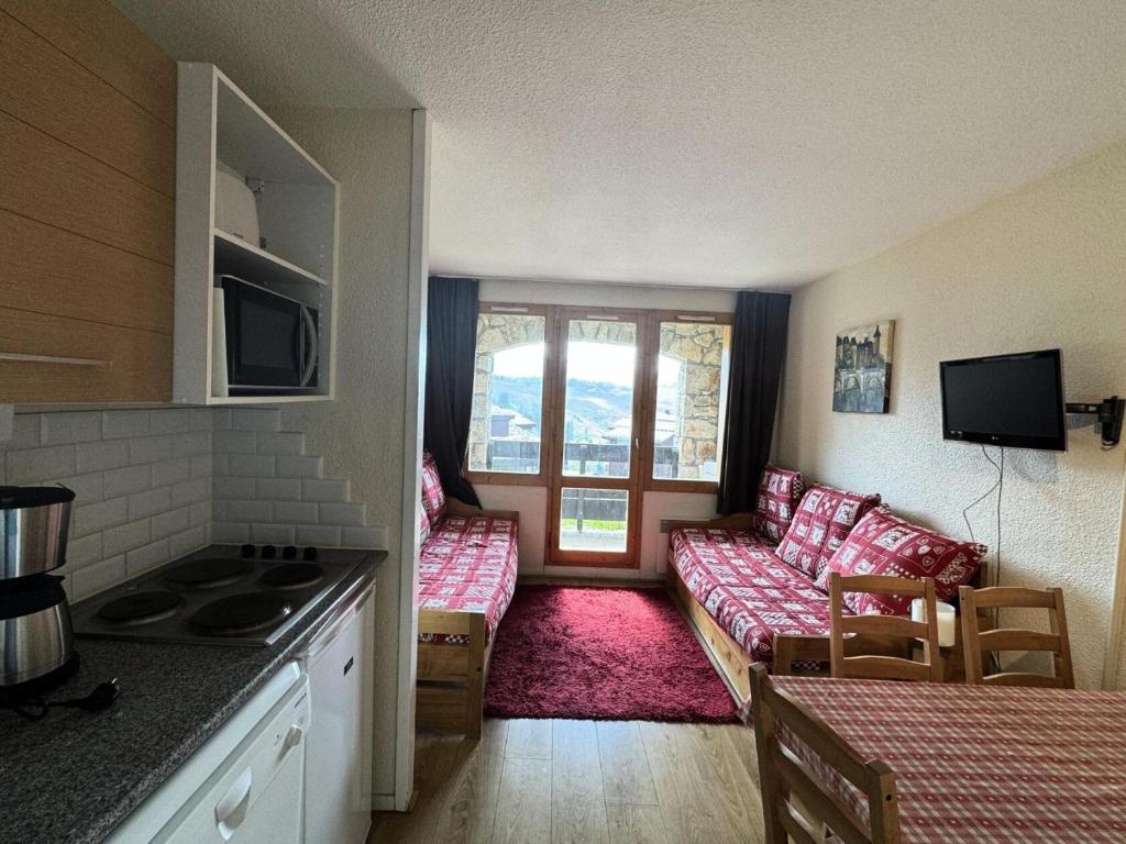 une cuisine et un salon avec un canapé dans l'établissement Résidence Andromede - 2 Pièces pour 5 Personnes 03, à Mâcot La Plagne