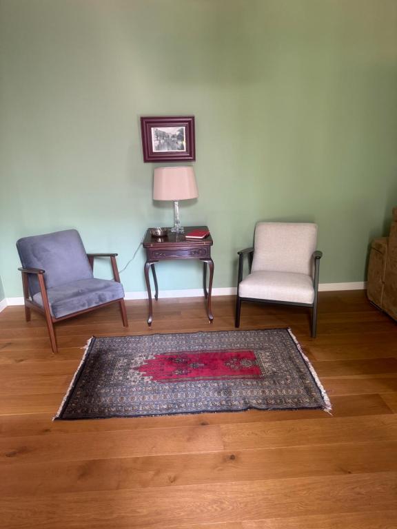 a living room with two chairs and a table at Casa Nina Carignano in Genoa