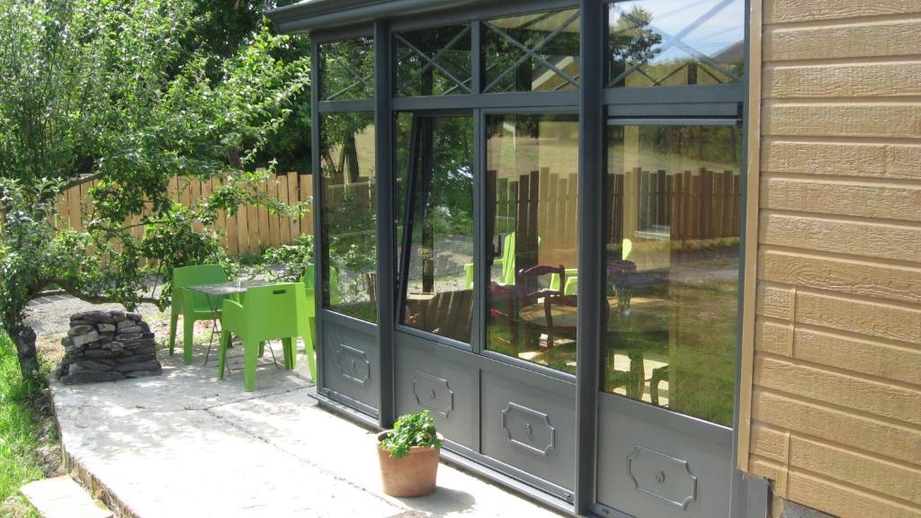 een afgeschermde patio met een tafel en stoelen bij Le Clos De La Roche in Goven