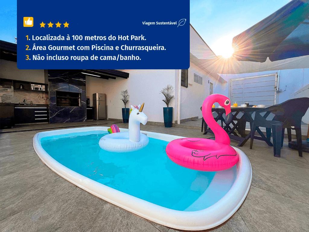 eine Werbung für aufblasbare Flamingos in einem Schwimmbad in der Unterkunft Casa Temporada Rio Quente (Em frente ao Hot Park) in Rio Quente