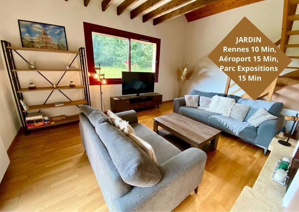 a living room with a couch and a tv at Petit Launay - proche Rennes in Vezin-le-Coquet